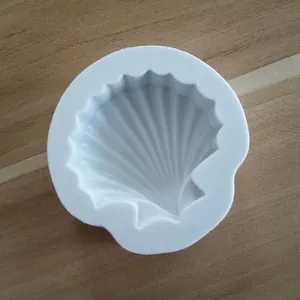 Close-up of white shell shaped silicone mold for DIY baking and chocolate cake decoration.
