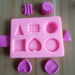 Détail d'un moule en silicone rose à 6 cavités montrant des formes de cœur et gaufre.