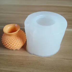 Detailed view of a 3D textured vase silicone mold alongside a finished orange resin sample