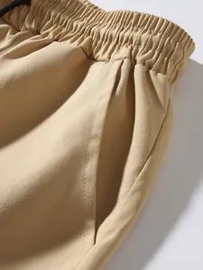 Close-up of khaki cargo pants detailing the elastic waistband and pocket design