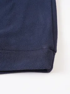 Close-up of navy blue fleece sweatshirt fabric showing soft texture and hem stitching detail.