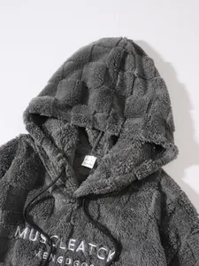 Primo piano di felpa grigia pelosa con ricamo bianco e etichetta della taglia.