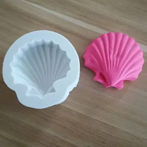 Close-up detail of a shell-shaped silicone mold alongside a pink seashell resin craft