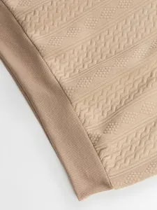 Close-up of the jacquard texture and ribbed hem on this men's casual tan sweatshirt.