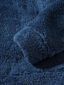 Macro view of navy blue soft plush fleece fabric texture on men's winter jacket
