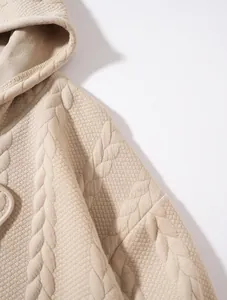 Gros plan détaillé du tissu jacquard à torsades du sweat à capuche beige pour hommes