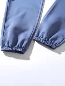 Detailed macro close-up of the elasticized ribbed cuffs on blue cotton jogger pants texture