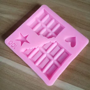 Primer plano de molde de silicona rosa con formas de corazón, estrella y chocolate