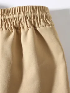 Detailed close-up showing the elastic waistband and twill texture of khaki cargo pants