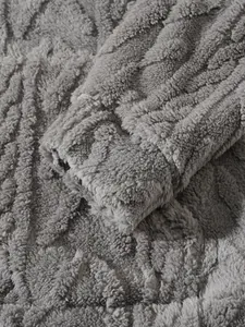 Detailopname van grijze pluche stof met golvende strepen op een warme herenhoodie mouw