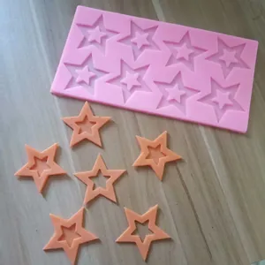 Detailed view of pink 8-cavity star silicone mold with finished orange fondant stars