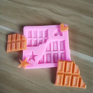 Detalle del molde de silicona rosa con chocolate partido, estrellas y corazones.