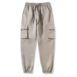 Close-up detail of khaki cotton cargo joggers featuring elastic waistband and side pockets