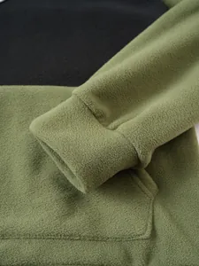 High-quality macro detail showing the soft green fleece fabric and sleeve cuff of a men's hoodie