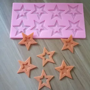 Detail view of pink 8-cavity star silicone mold with finished orange fondant pieces.