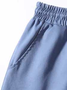 Close-up detail of men's blue cargo pants showing elastic waistband and side pocket.