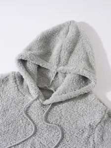 Nahaufnahme der flauschigen Fleece-Textur und Kapuze eines grauen Herren-Sweatshirts