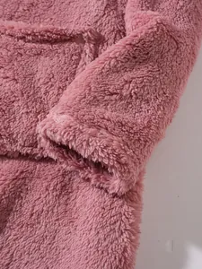 Close-up shot of the soft pink plush sweatshirt fabric texture and sleeve cuff details