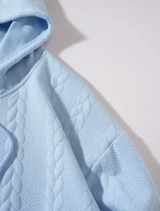 Détail de la texture jacquard bleu clair sur un sweat à capuche décontracté pour homme