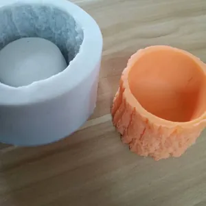 Detailed view of the tree stump silicone mold alongside the finished orange pot.