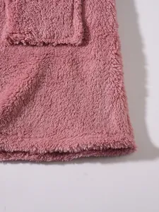 Macro detail view of soft pink plush fleece material showing fabric texture and pocket seam.
