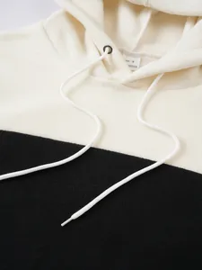 Close-up of black and cream bicolor polar fleece hoodie with adjustable drawstring detail