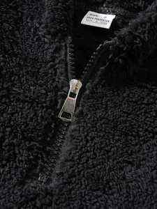 Detailed view of black sherpa fleece jacket with silver metal zipper and size tag
