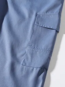 Macro view showing the fabric texture and cargo pocket stitching of blue cotton pants.