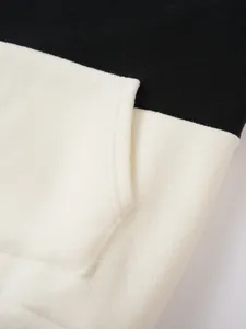 Detail shot of black and white fleece hoodie showing soft texture and pocket stitching.
