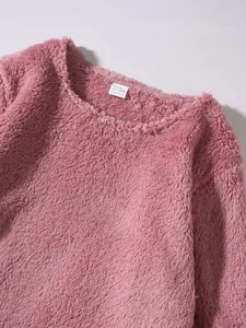Detailed view of soft pink fuzzy fleece sweatshirt showing collar and product inner tag