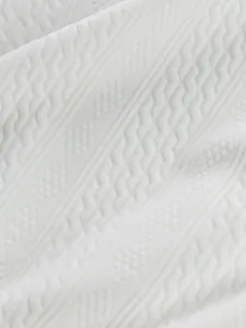 Close-up view of premium white jacquard fabric with geometric patterns on hoodie