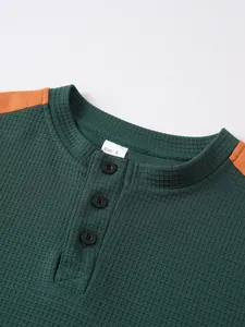 Detailansicht der Waffelstrickstruktur und der Knopfleiste am grünen Henley-Shirt