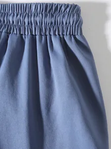 Close-up detail showing the elastic waistband and blue twill fabric of men's cargo pants