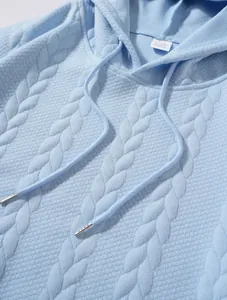 Gros plan sur le motif en maille torsadée jacquard bleu clair d'un sweat à capuche