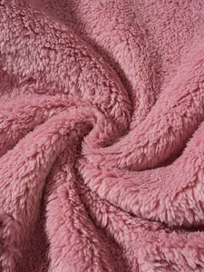 Close-up texture detail of the soft pink sherpa fleece fabric for a cozy winter sweatshirt