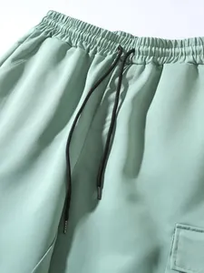 Close-up of mint green joggers featuring an elastic waistband and black drawstring.
