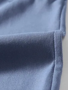 Macro view of blue twill fabric texture on men's cargo pants showing detailed weave