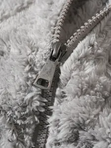 Gedetailleerde macro-opname van de metalen rits op een zachte grijze fleece herenhoodie