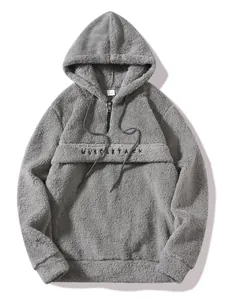 Close-up of grey fuzzy fleece hoodie with half-zip and MuscleTack embroidery detail