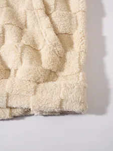 Primo piano del tessuto sherpa beige con motivo a scacchi in rilievo per felpa accogliente