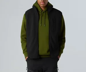 Detail view of a black fleece vest with stand collar on a model over a hoodie