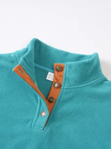 Close-up detail of a men's turquoise fleece sweatshirt with a brown button placket