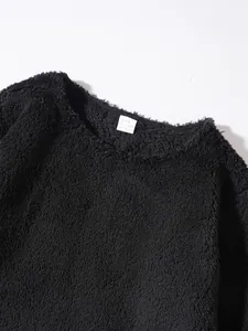 Detail of black fuzzy sweatshirt showing round neck and soft texture.