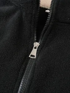 Detaillierte Nahaufnahme eines Metallreißverschlusses an einem schwarzen Fleecepullover