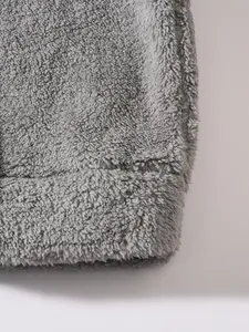 Close-up macro view of high-quality grey plush fleece fabric showing soft texture and hem