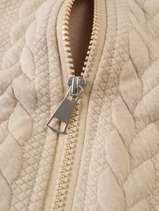 Close-up of durable metal zipper on men's beige jacquard quilted sweatshirt