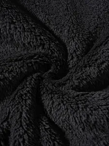 Macro detail view of soft black plush fabric texture for winter sweatshirt