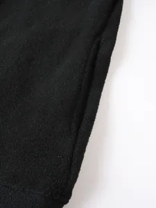 Makroansicht der weichen Textur und Seitentasche des schwarzen Fleece-Sweatshirts