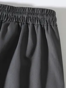 Close-up of elastic waistband on men's vintage black high street style cargo jogger pants.
