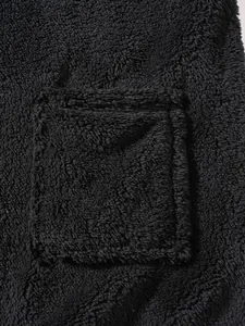 Detailed close-up showing the soft black fluffy fleece fabric and pocket of the top